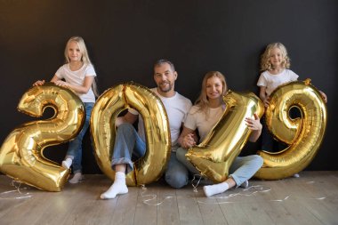 Mutlu aile işareti 2019 holding yeni yıl için altın balon siyah arka plan üzerine yapılan.