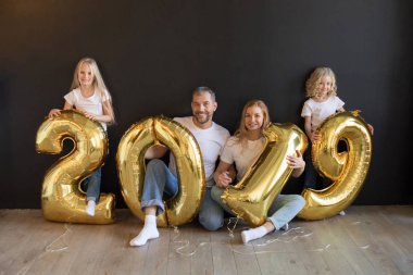 Mutlu aile işareti 2019 holding yeni yıl için altın balon siyah arka plan üzerine yapılan.