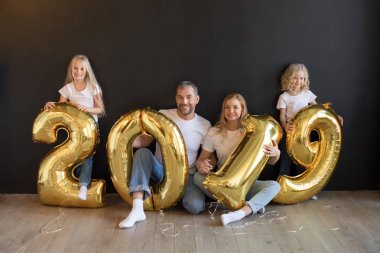 Mutlu aile işareti 2019 holding yeni yıl için altın balon siyah arka plan üzerine yapılan.