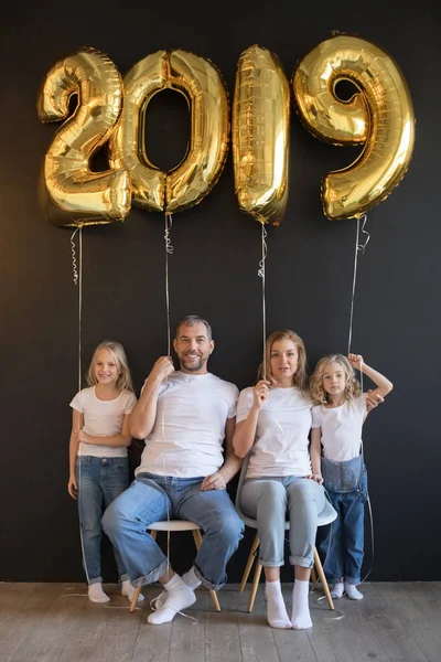 Gelukkige familie bedrijf teken 2019 gemaakt van gouden ballonnen voor Nieuwjaar op zwarte achtergrond. — Stockfoto