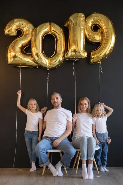 Gelukkige familie bedrijf teken 2019 gemaakt van gouden ballonnen voor Nieuwjaar op zwarte achtergrond. — Stockfoto