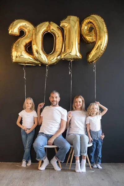 Gelukkige familie bedrijf teken 2019 gemaakt van gouden ballonnen voor Nieuwjaar op zwarte achtergrond. — Stockfoto