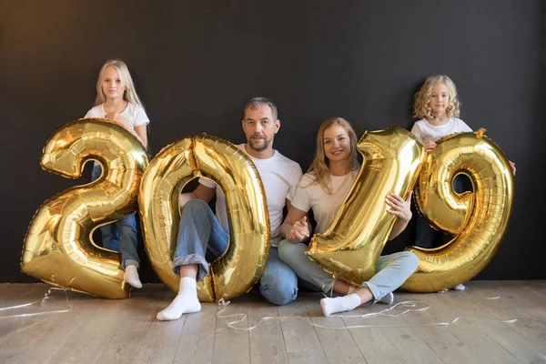 Gelukkige familie bedrijf teken 2019 gemaakt van gouden ballonnen voor Nieuwjaar op zwarte achtergrond. — Stockfoto