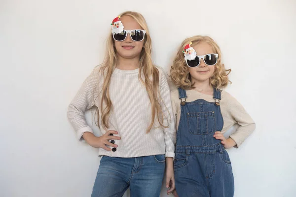 Deux petites filles dans des lunettes drôles sous la forme d'arbres de Noël . — Photo