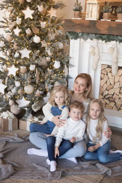 Noel ağacının yanında oturan çocuklar ile anne. — Stok fotoğraf