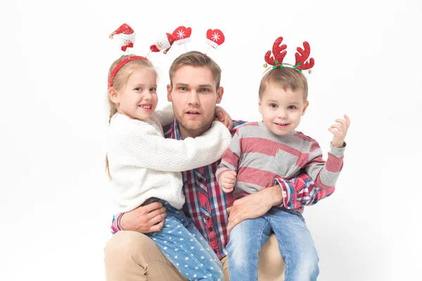 Père avec des enfants dans les bandeaux de Noël drôles sur fond blanc . — Photo