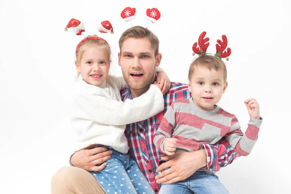 Père avec des enfants dans les bandeaux de Noël drôles sur fond blanc . — Photo