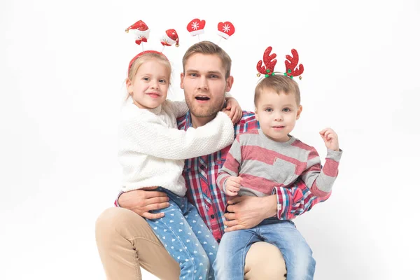 Père avec des enfants dans les bandeaux de Noël drôles sur fond blanc . — Photo