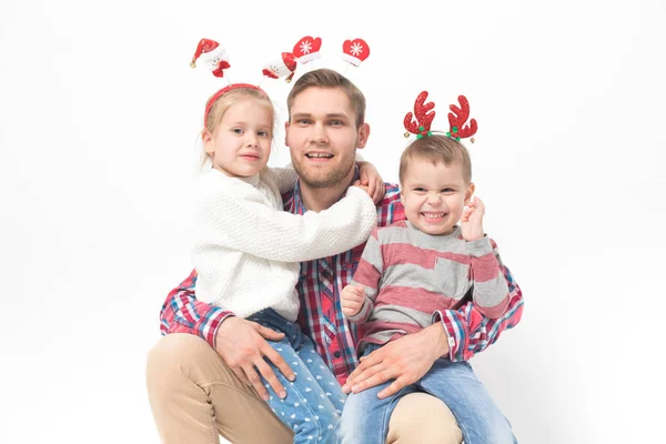 Père avec des enfants dans les bandeaux de Noël drôles sur fond blanc . — Photo