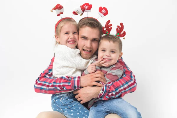 Père avec des enfants dans les bandeaux de Noël drôles sur fond blanc . — Photo