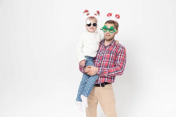 Père et fille dans des accessoires de Noël drôles sur un fond blanc . — Photo