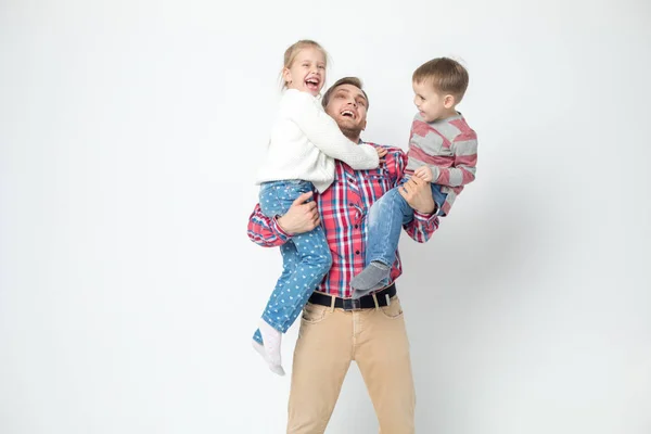 Pappa med barn ha roligt på en vit bakgrund. Far håller dotter och son. — Stockfoto