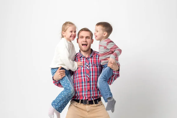 Отец с детьми веселится на белом фоне. Отец держит дочь и сына . — стоковое фото