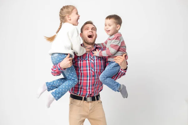 Pappa med barn ha roligt på en vit bakgrund. Far håller dotter och son. — Stockfoto