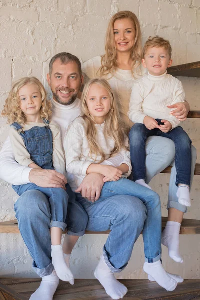 Joyeux famille assis dans les escaliers à la maison . — Photo