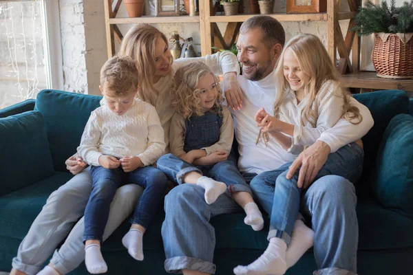 Lycklig familj sitter i soffan och ha kul. — Stockfoto