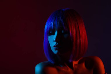 Studio, güzel seksi kız portresi poz renkli parlak ışıklar kadında.
