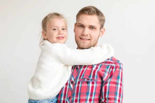 Pappa håller dotter i famnen på vit bakgrund. — Stockfoto