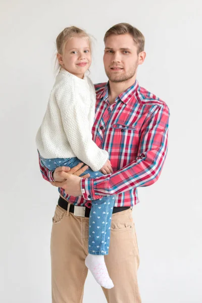 Papa tient sa fille dans ses bras sur fond blanc . — Photo