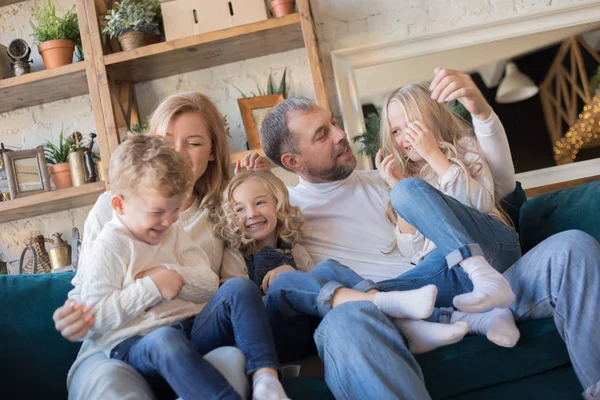 Lycklig familj sitter i soffan och ha kul. — Stockfoto