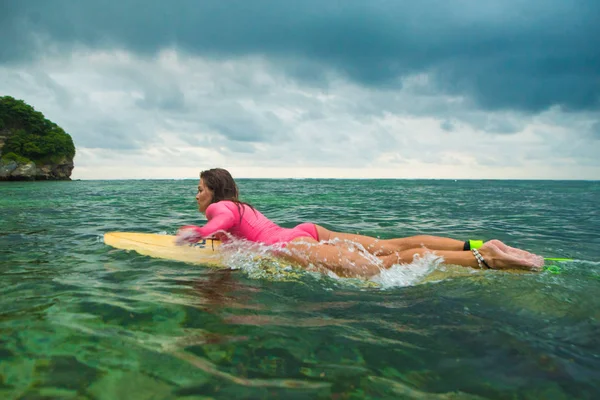 Vacker kvinna simmar på en surfbräda. — Stockfoto