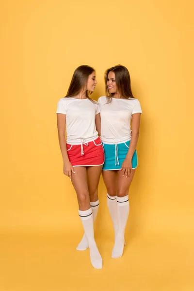 Jeunes femmes en t-shirts blancs et jupes de sport lumineuses. Maquette . — Photo
