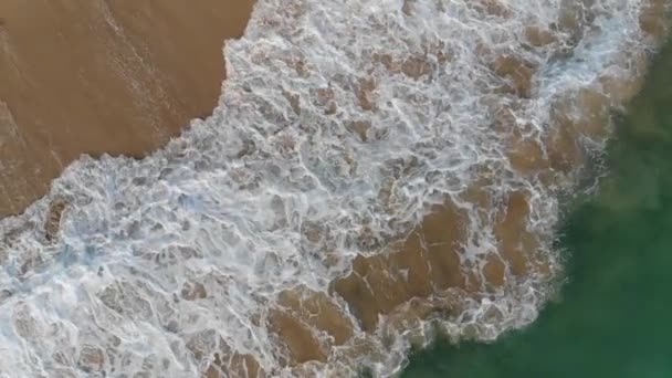 Bovenaanzicht van de oceaan golven wassen van het zandstrand. — Stockvideo