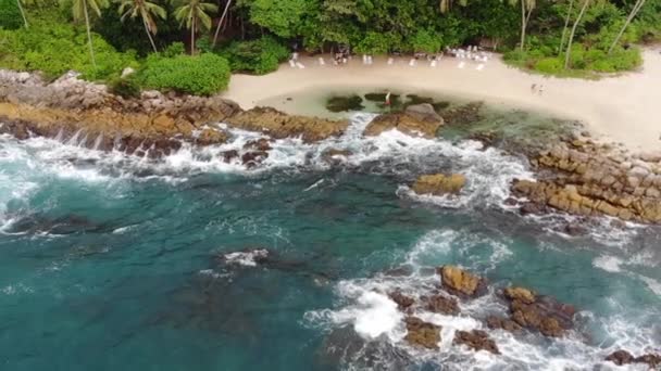 Vista superior de una isla tropical con una costa de piedra bañada por el océano . — Vídeos de Stock