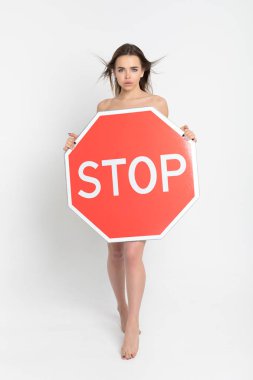 Elinde büyük kırmızı bir dur işareti tutan seksi genç kadın..
