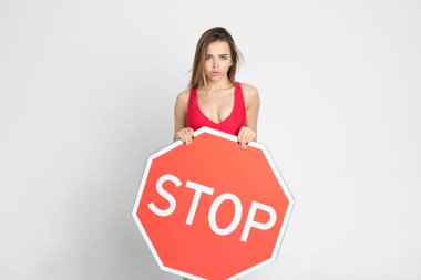 Elinde büyük kırmızı bir dur işareti tutan seksi genç kadın..
