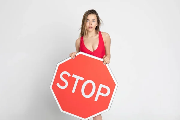 Сексуальная молодая женщина с большим красным знаком "стоп" . — стоковое фото