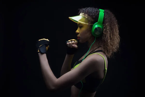 Athletic Girl Afro American luistert naar muziek op oortelefoons en bereidt je voor op de strijd. — Stockfoto