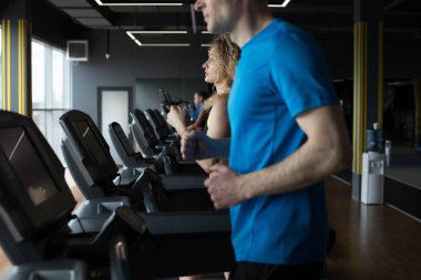 Spor salonunda koşan bir çift.,