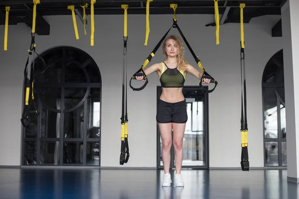 Kvinna som tränar på ringarna i gymmet. — Stockfoto