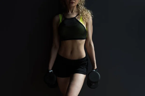 Athletische Frau macht Übungen mit Kurzhanteln im Fitnessstudio. — Stockfoto
