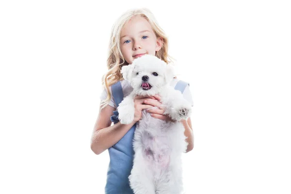 Küçük kız beyaz arka plan üzerinde kollarında beyaz köpek yavrusu tutan. — Stok fotoğraf