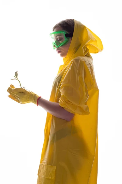 Young plant sprout in the hands of a woman in protective clothing. Woman saves the plant. — Stock Photo, Image