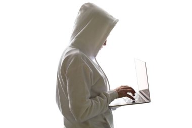 Kapüşonlu bir kadın dizüstü bilgisayar kullanıyor. Hacker bir dizüstü bilgisayar kullanıyor.