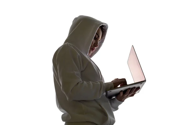 Eine Frau mit Kapuze benutzt einen Laptop. Hacker benutzt Laptop. Hacker- und Web-Angriffskonzept. — Stockbild Eine Frau mit Kapuze benutzt einen Laptop. Hacker benutzt Laptop. — Stockfoto