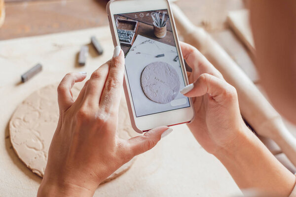 Woman makes a photo of her work from clay with the words "family".