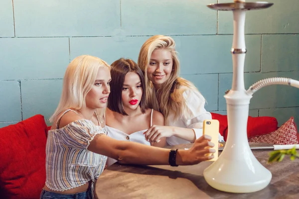 Belles jeunes femmes font selfie dans un endroit narguilé . — Photo