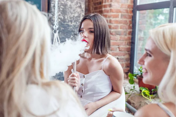 Vacker ung kvinna röker en hora. — Stockfoto