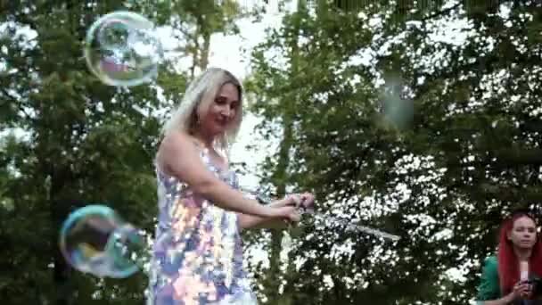 Vologda, Rusko, červenec 2019: dívka vytváří spoustu mýdlových bublin máváním rukou — Stock video