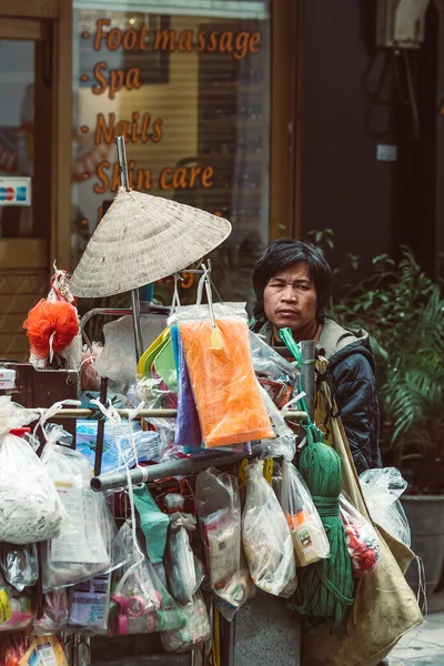 HANOI, VİETNAM - 15 Aralık 2018 Hanoi 'nin Eski Mahallesi. Sokak satıcısı bisikletten çeşitli geleneksel Vietnam şapkaları satıyor.