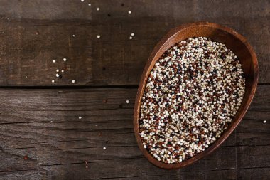 Tricolored ham quinoa tahıl bir ahşap kase görünümünü kopya alanı rustik zemin üzerine yukarıda