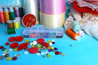 Stüdyoda bir terzi ve tasarımcının işyeri. Dikiş işi ve giysi ve aksesuarların terziliği: iplikler, kurdeleler, dantel, kumaşlar, boncuklar, iğneler, düğmeler.