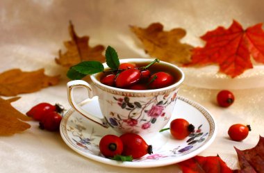 Rosehip çayı ve kırmızı akçaağaç yaprakları. Sonbahar