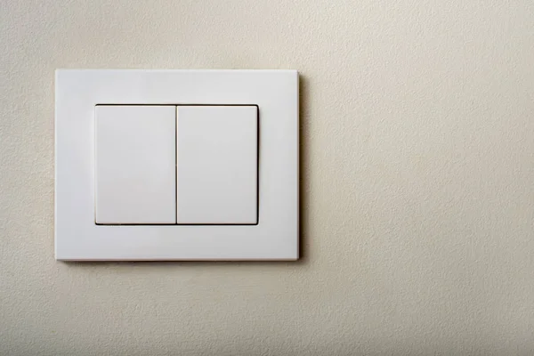 Close up white light switch with Ivory color texture background. Copy space.