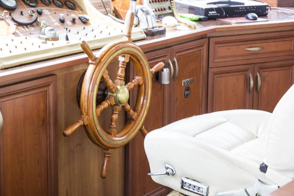 Captain's cabin boat, wooden steering wheel. Cabin equipment for boat management