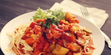 Şerit Arrabiata soslu makarna. Yakın çekim. Akdeniz çanağı. Tagliolini sebzeli makarna. Karnabahar, kabak ve domates yahnisi. İtalyan mutfağı. Vegan ve vejetaryen. Geniş fotoğraf.